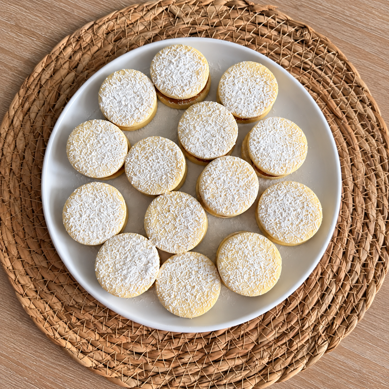 Handmade round dulce de leche alfajores dusted with powdered sugar, photographed from above